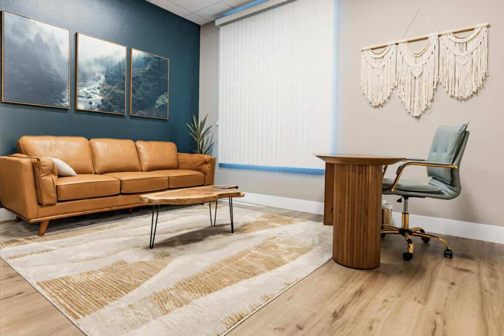 A comfortable treatment room at Alpine Wellness with a leather couch and desk where you can see us for women's health concerns that you don't necessarily need a gynecologist in Reno for.