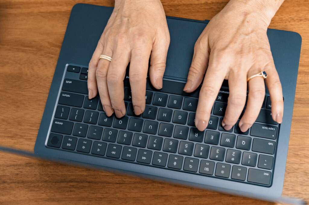 A patients hands use a laptop to refill their prescription for concierge primary care in Reno.