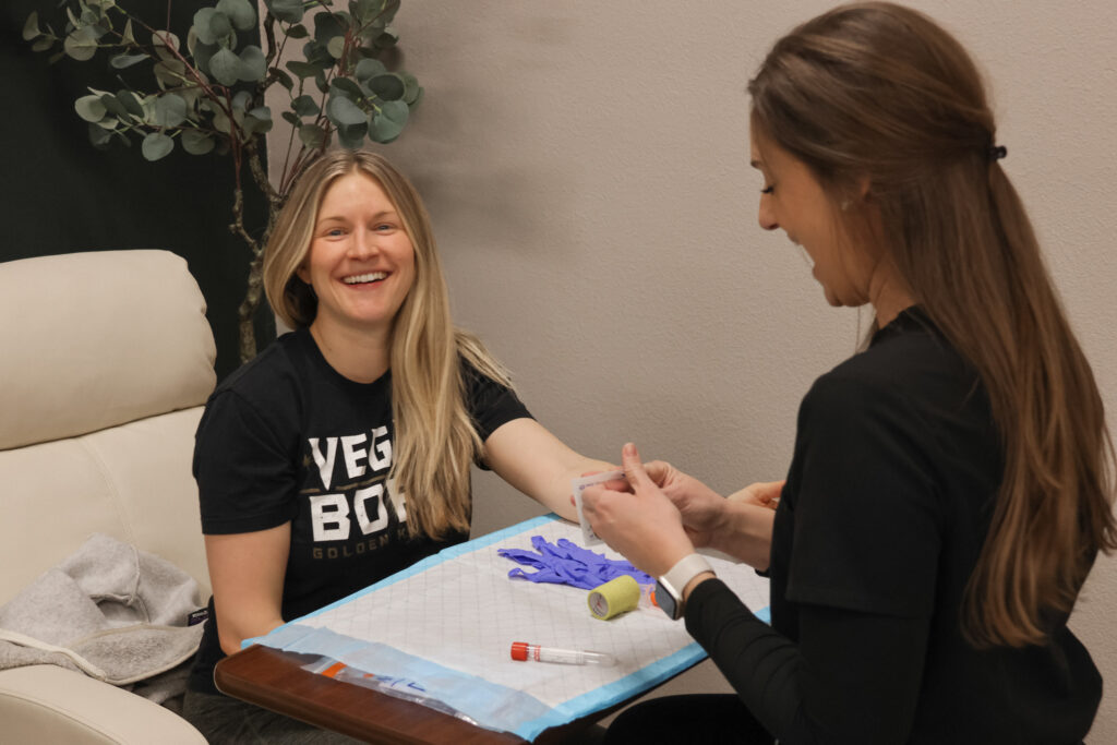 A team member administers a blood test to a woman receiving integrative women's health care with us, rather than with a gynecologist in Reno.